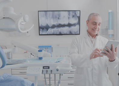 um dentista no consultório olhando um tablet