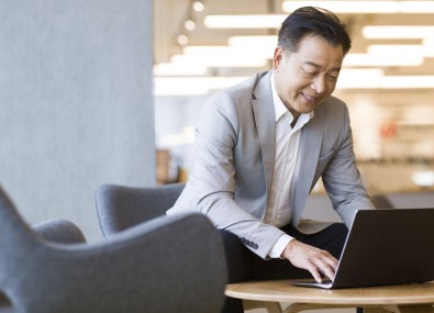 Homem sorrindo mexendo no computador