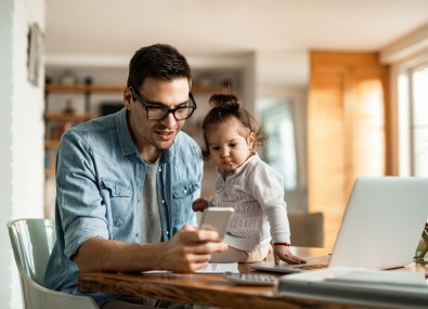 Pai mexendo no celular com sua filha