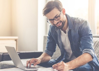 Homem escrevendo e mexendo no computador