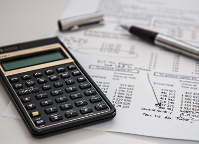 Mesa com caneta, papel e calculadora