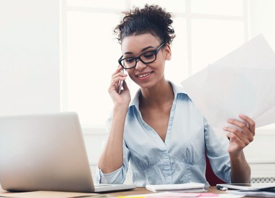 Mulher falando no telefone segurando papel