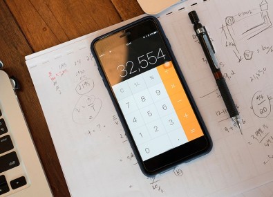 Celular em app de calculadora na mesa com papel