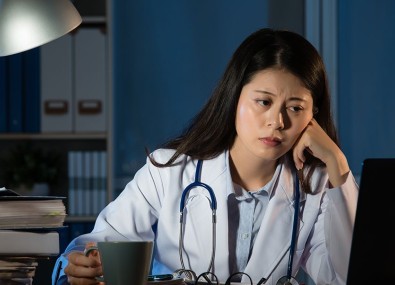 Mulher segurando xícara de café e vendo computador