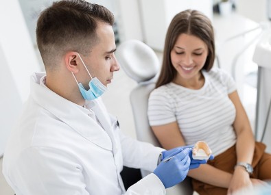 Dentista e paciente vendo modelo dental