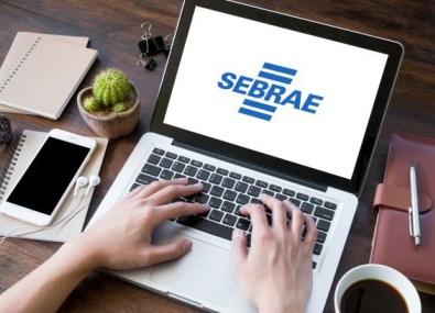 Computador com tela da logo do Sebrae