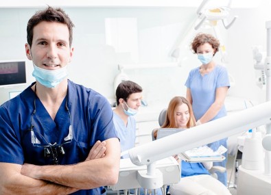 Doutor sorrindo com pacientes e outros doutores fazendo exame