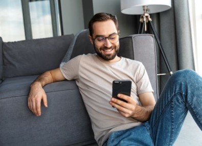 Homem vendo celular e sorrindo