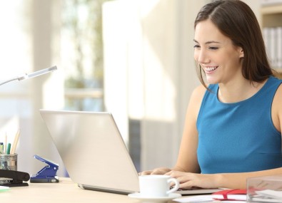 Mulher sorrindo olhando para computador