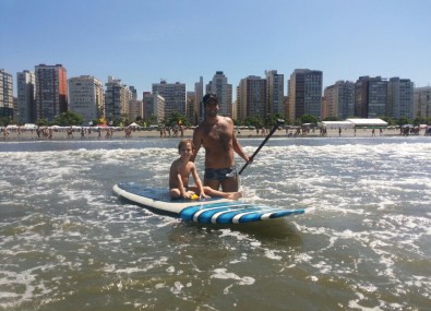 Pai e filho em uma prancha de surfe 