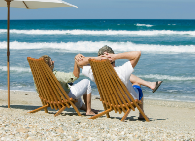 Homem e mulher sentados em cadeira na praia